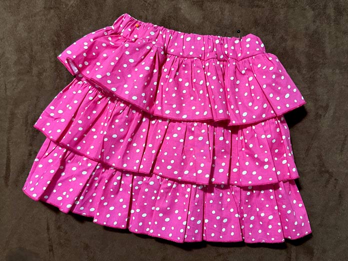 Pink polka dot tiered skirt, each tier is gathered, and the hem is a rolled edge in pink, while the upper edge is attached to the skirt base; PFAFF admire air 7000 serger 