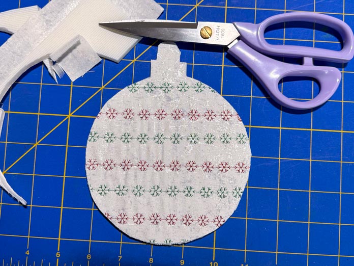 Using the purple DHL scissors, the ornament shape is cut out of the Bosal. 