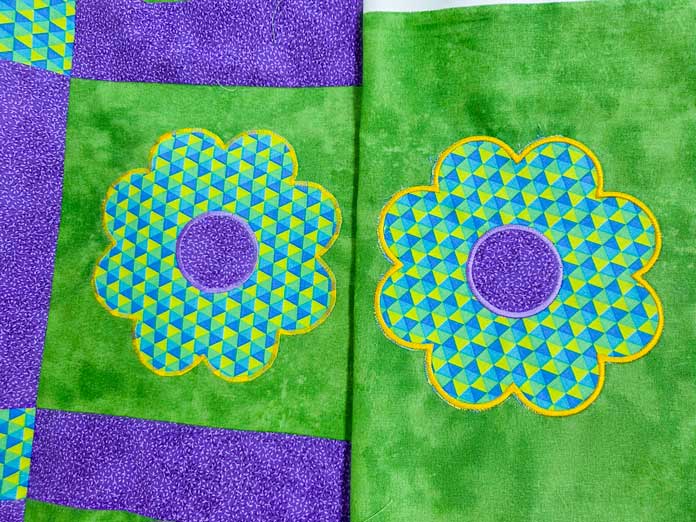 Two fabric flowers on green fabric