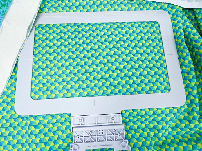 A metal embroidery hoop and green, yellow, and blue fabric; Creativate Embroidery Software; Creativate Embroidery Software