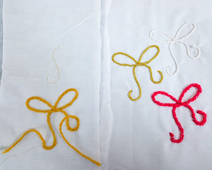Four bows stitched in gold yarn, gold cord, white cord, and red yarn