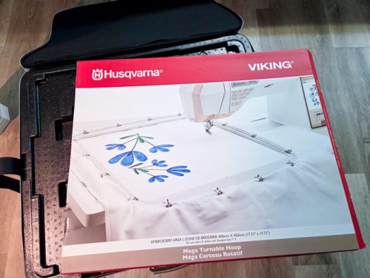 A red and white box with an embroidery hoop on the front