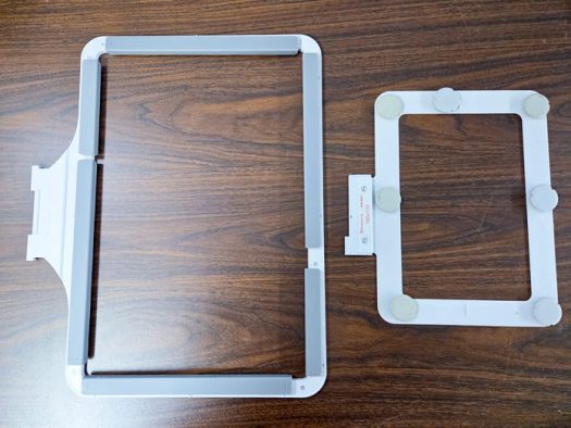 A magnetic machine embroidery hoop beside a metal embroidery hoop