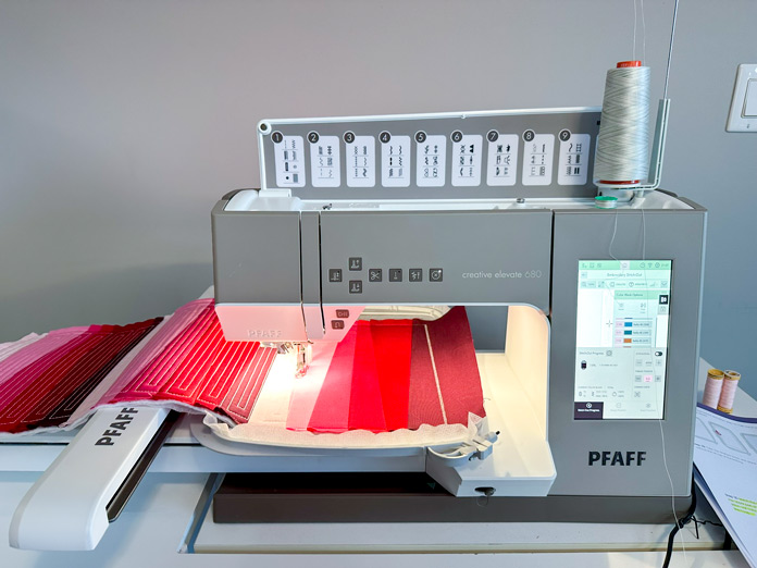 A picture of the PFAFF creative elevate 680 with a section of the creativate “Endless Quilted Table Runner” project in the hoop.