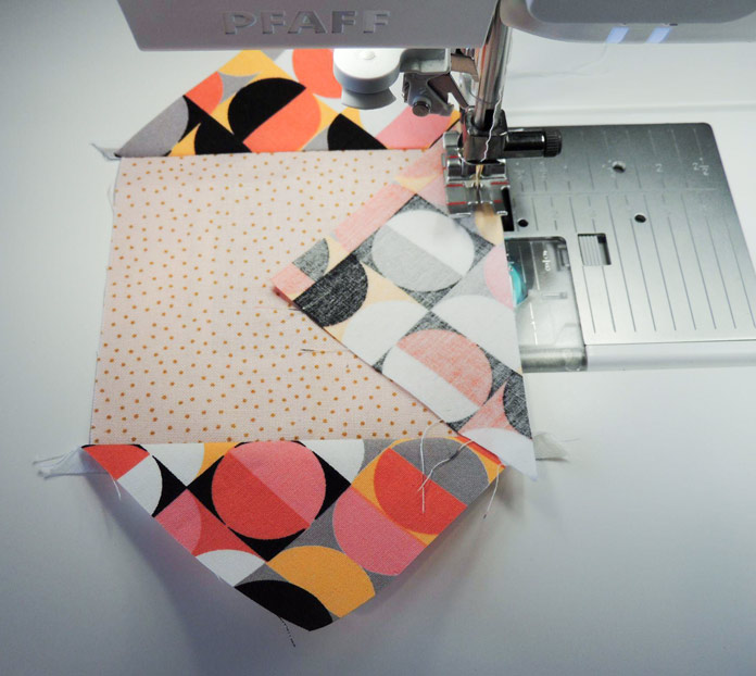 Sewing on the third piece of triangle fabric onto the square piece of fabric; PFAFF performance icon