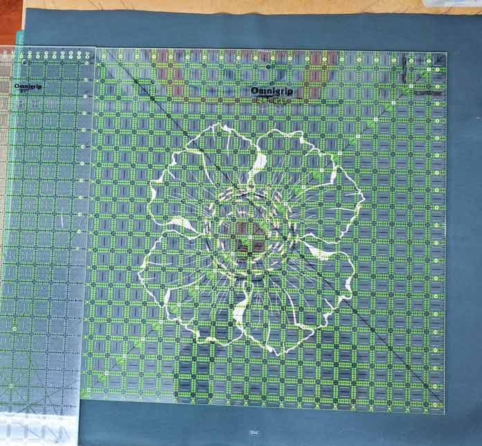 Two large quilting rulers on a white embroidery flower on green fabric. Husqvarna Viking Designer Sapphire 85, Inspira EZ Snip Curved Scissors
