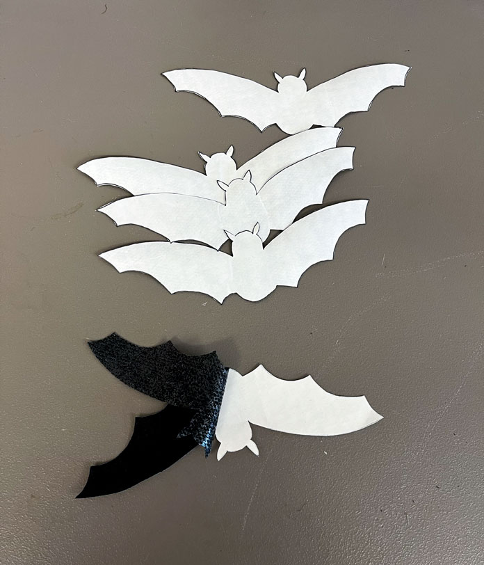 Showing the paper being removed from the bats revealing the glue side of the fabric adhesive