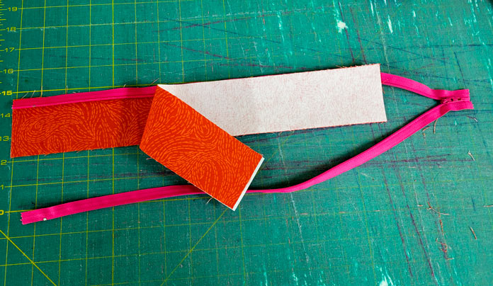 A pink zipper with two pieces of orange fabric; making a project bag on the Husqvarna VIKING ONYX 25 