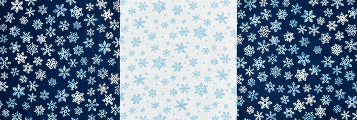 A row of the quilt top made from a dark blue, white and another dark blue snowflake fabric.