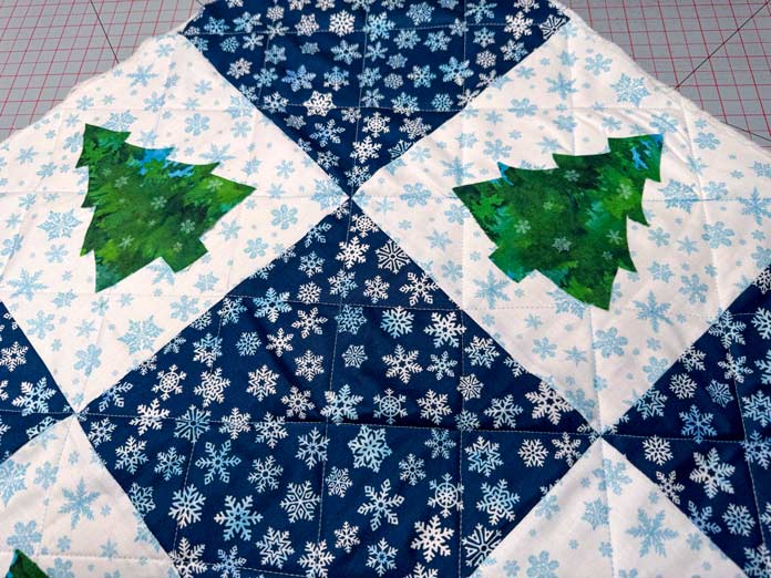 Two trees are glued to the nine-patch quilt top.