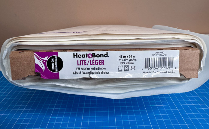 A bolt of HeatnBond Lite Iron-On Adhesive; Gütermann Dekor Metallic Thread 200m – Gold, Gütermann Dekor Metallic Thread 200m - Col. 41, Gütermann Dekor Metallic Thread 200m – Red, Gütermann Dekor Metallic Thread 200m - Christmas Green, Gütermann Dekor Metallic Thread 200m - Col. 1005, Gütermann Denim Thread 100m – Black, UNIQUE Baby Rick Rack 3mm x 3.7m – Scarlet, UNIQUE Medium Rick Rack 6mm x 2.3m - Emerald Green, UNIQUE Jumbo Rick Rack 10mm x 2.3m - Metallic Gold, SCHMETZ #1743 Metallic Needles Carded - 80/12 - 5 count, SCHMETZ #1752 Metallic Needles Carded - 90/14 - 5 count, LDH 8½“ Craft Scissors – Purple, HeatnBond Lite Iron-On Adhesive - 43cm x 30m (17″ x 32 ¾yds) bolt, HeatnBond Stitch n Sew Tear-Away Stabilizer - 50.8cm x 22.8m (20″ x 25yds), oliso M3Pro Project Iron – Coral, OLFA 45mm RTY-2/DX/MAG Ergonomic Rotary Cutter – Magenta, UNIQUE QUILTING Wool Pressing Mat - 18″ x 24″ - Grey 