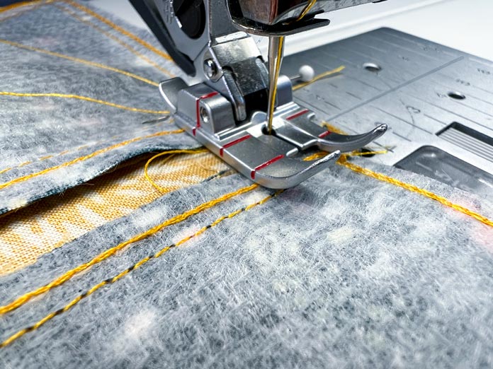 Close-up process of stitching with a PFAFF ¼” Quilting Foot for IDT System