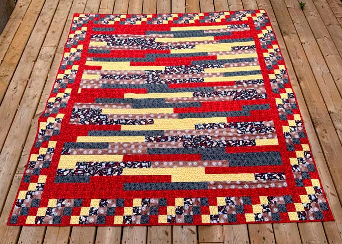 The jelly roll quilt with a checker border is completed.