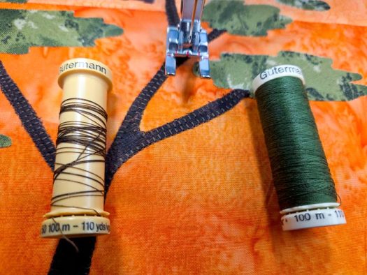 A spool of brown thread and a spool of green thread