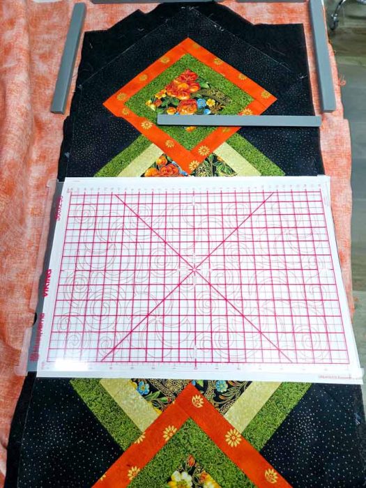 A template with red grid lines on a black and green table runner