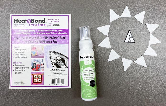 HeatnBond Lite Iron-On Adhesive, a bottle of Fabric Fuse by HeatnBond Quickbond Fabric Adhesive and small white triangles circle the triangle template