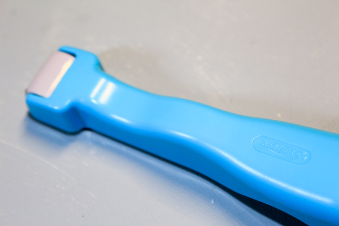 The Clover Roll & Press tool from Clover with its blue ergonomic handle 