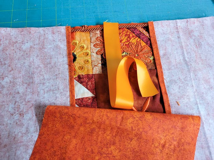 A piece of orange ribbon and orange fabric