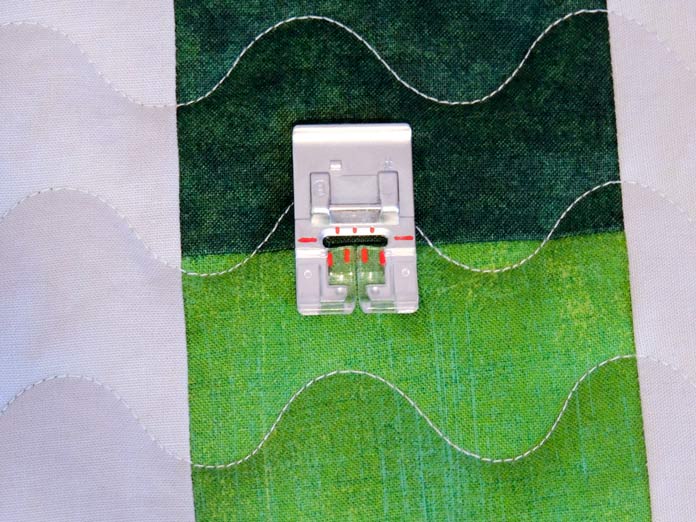 A sewing machine presser foot on a quilted placemat. PFAFF performance icon sewing machine