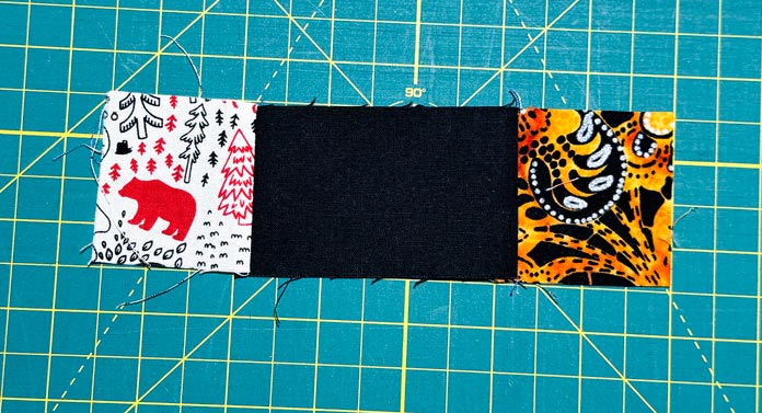 A 2” x 3½” black rectangle has 2” x 2” squares sewn on each end.
