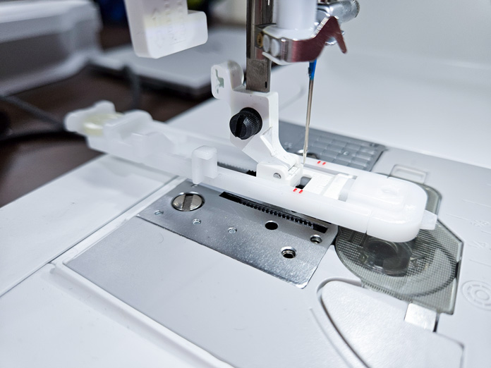 A white buttonhole foot attached to a sewing machine; Husqvarna VIKING Designer Quartz 29