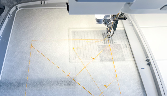 PFAFF 6D Dynamic Spring Foot at work, guided by the ghost-stitched diagram of the built-in patchwork block 1
