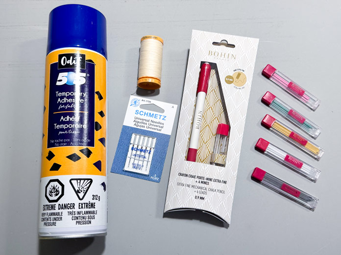A can of Odif 505 Temporary Quilt Basting Adhesive, a spool of Gütermann ivory Cotton thread, a package of SCHMETZ needles, A BOHIN mechanical pencil and refills.