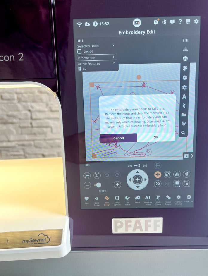 A purple model of the PFAFF creative icon 2 capacitive touch screen pop up message with a reminder that the embroidery unit needs to calibrate