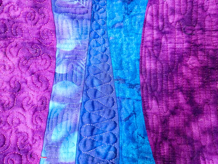 Machine stitching on blue and purple fabrics