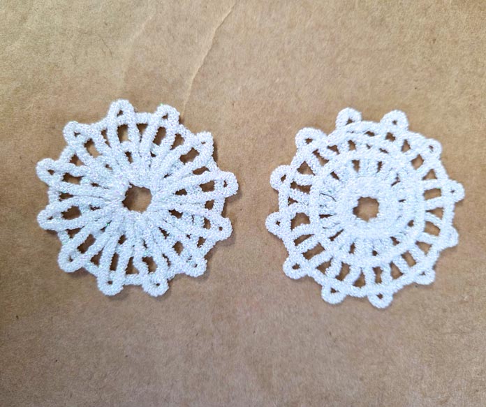 Two white machine-embroidered motifs