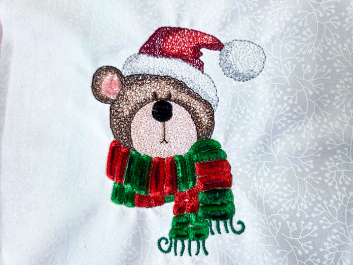 A Christmas bear stitched on white fabric