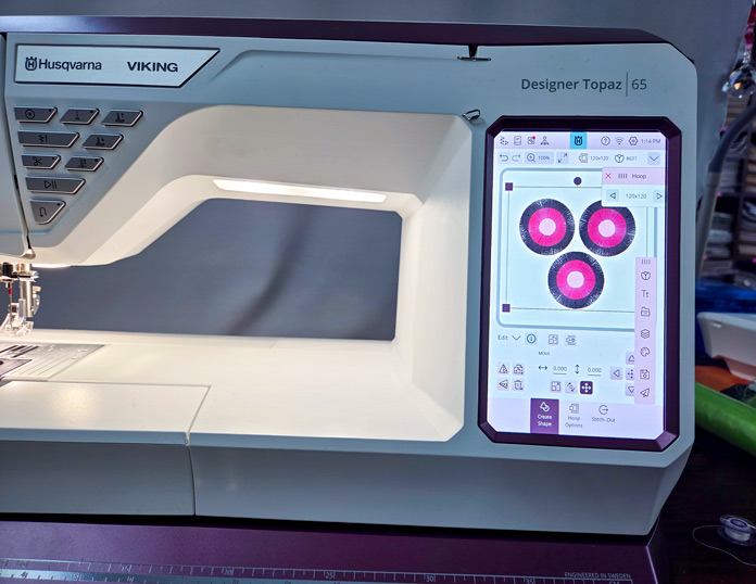 Three floral designs on the screen of a computerized embroidery machine