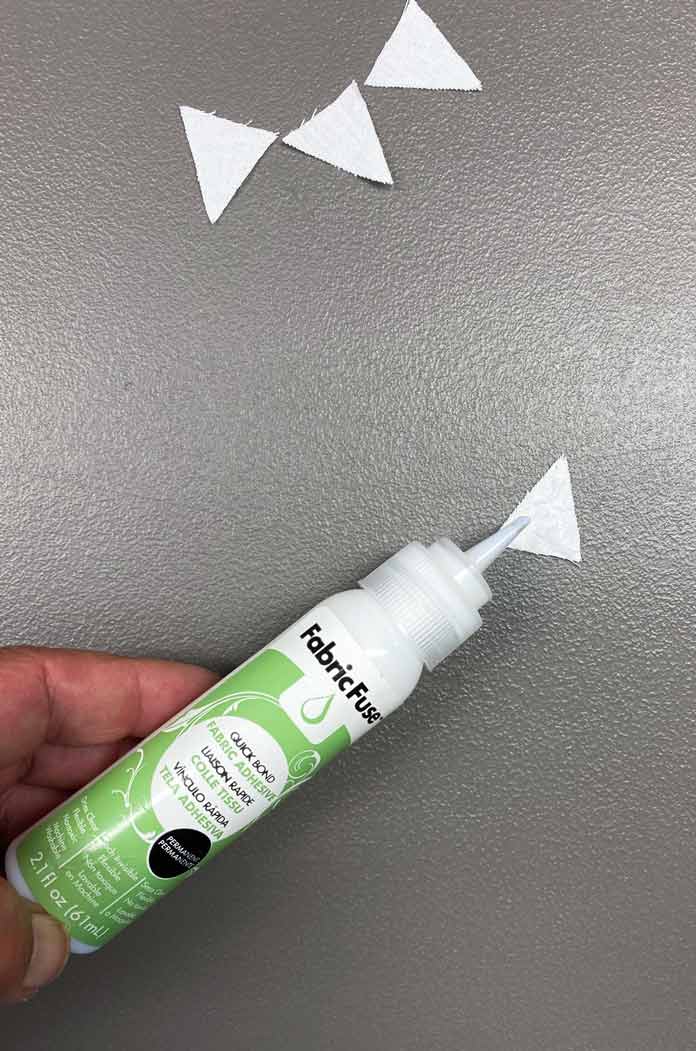 Fabric Fuse by HeatnBond Quickbond Fabric Adhesive is applied to a triangular piece of fabric