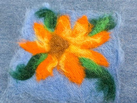 A yellow and orange flower on blue denim
