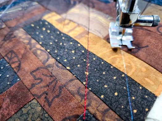 Lines of stitching on scrappy, brown fabric