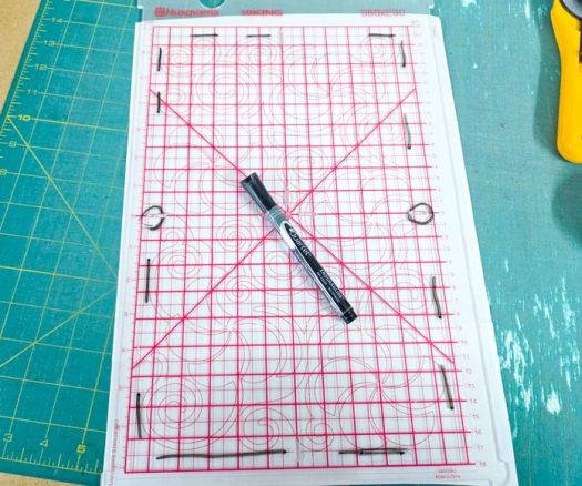 A black dry-erase marker on a template with a red grid
