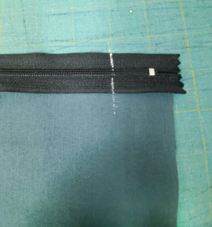 The end of a black zipper with a white chalk placement line. Husqvarna Viking Designer Sapphire 85, Inspira EZ Snip Curved Scissors
