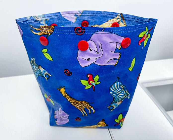 All-purpose bag made of blue print fabric covered with Odif Odicoat Gel Coating and closures made with ⅜" UNIQUE Sewing Plastic Snap Fasteners