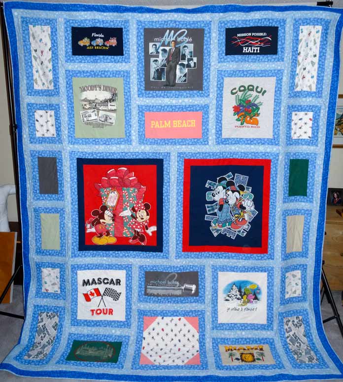 Multiple squares made of various fabrics are bordered with medium blue fabric. The blocks are then separated with a light blue fabric