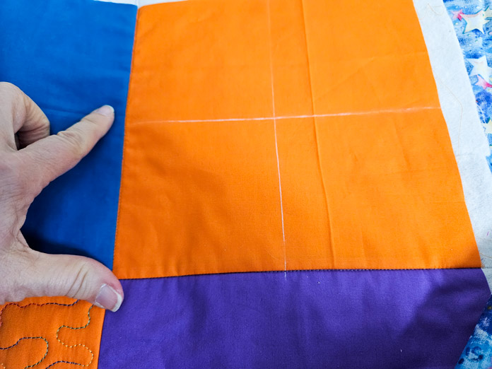 An orange quilt square with white chalk lines; Clover Chaco Liner