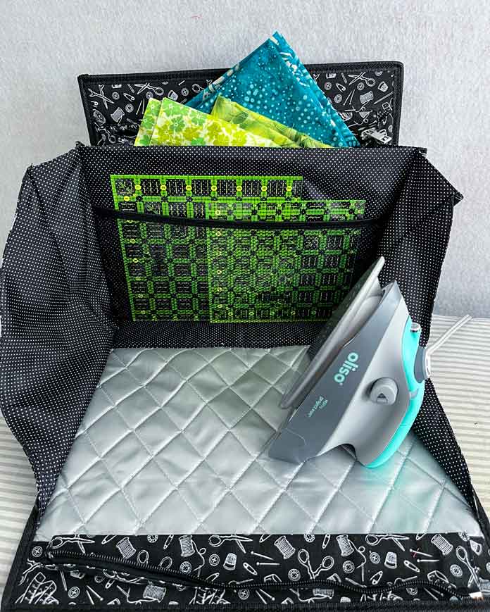 The inside of the black and white Multi–Use Craft Bag showing ironing mat and storage pockets