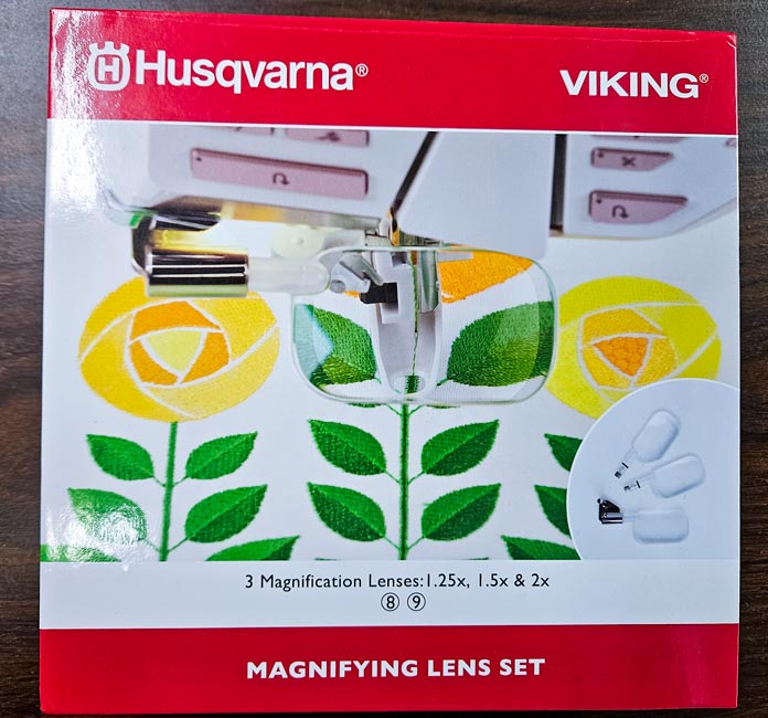 A red and white box with green and yellow flowers; Husqvarna VIKING DESIGNER EPIC 3