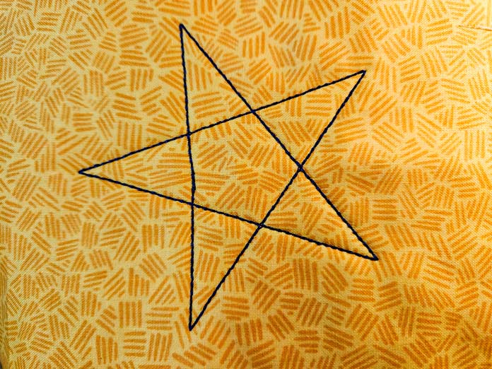 A star of blue lines on yellow fabric