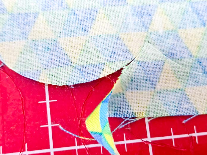 Blue, green, and yellow fabric on a red mat