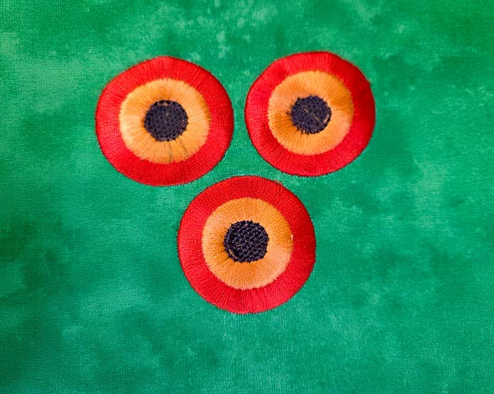 Three orange, gold, and brown stitched designs