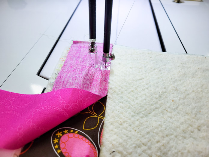 Pink and brown fabric and batting under a square plastic foot on a stationary quilting machine; Husqvarna Viking PLATINUM™ Q160, Husqvarna Viking Square Feet Set