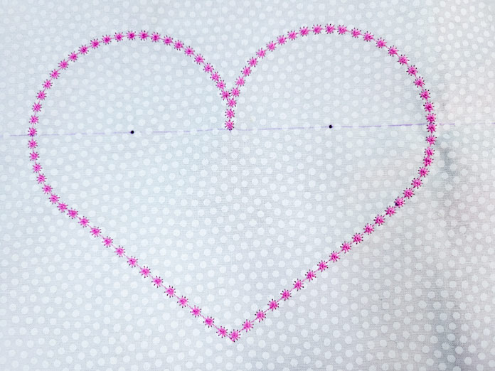 A pink heart on white fabric