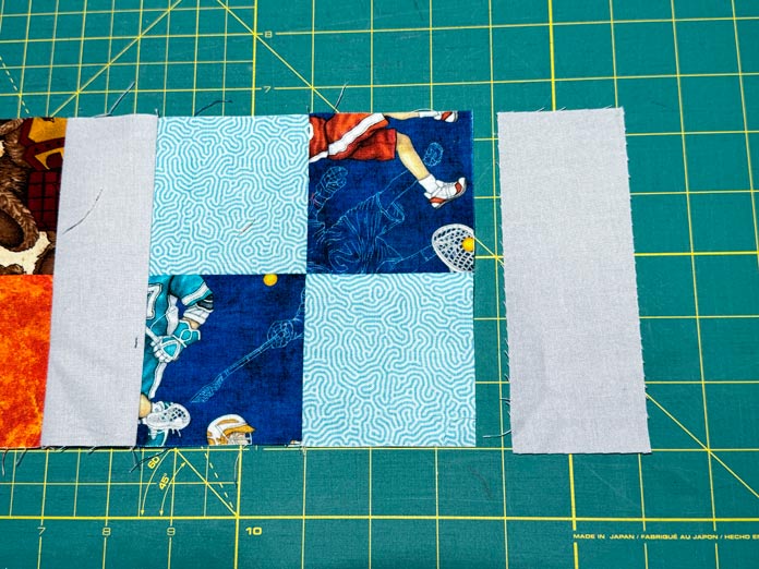 A 2” x 5½” rectangle is placed next to the end of a four-patch row before being sewn.