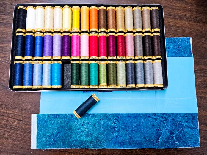A tin with 48 different spools of thread