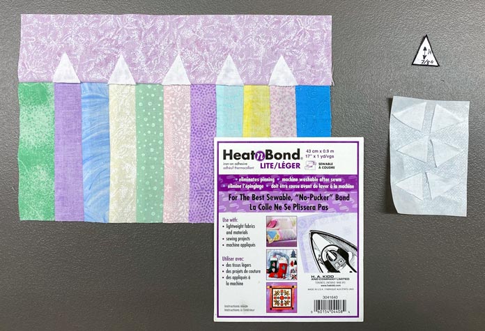 The sewn piece of fabric with pastel colors next to HeatnBond Lite Iron-On Adhesive, white fabric triangles on parchment paper, and the triangle template